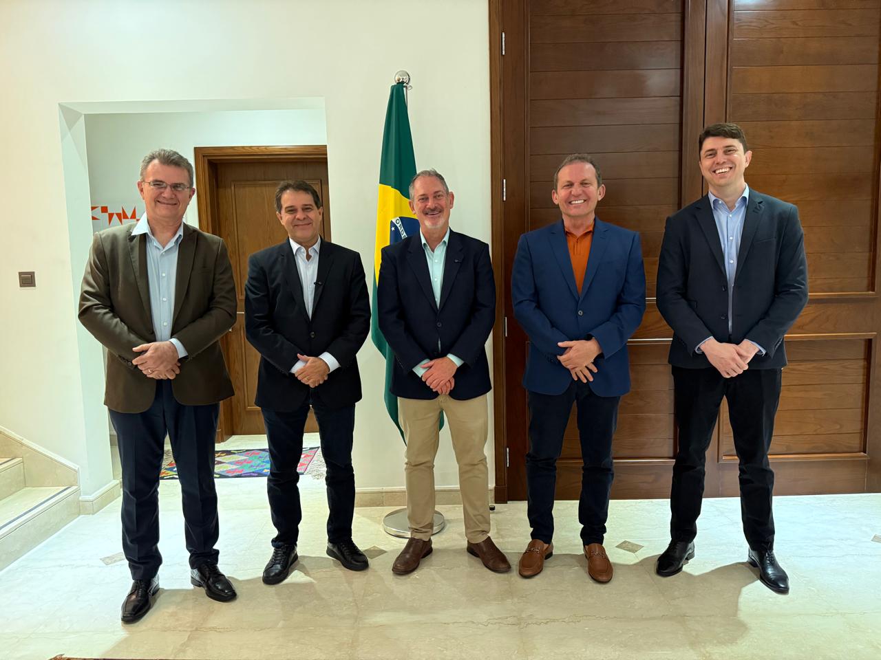 grupo de pessoas posa para a foto em pé dentro de uma sala